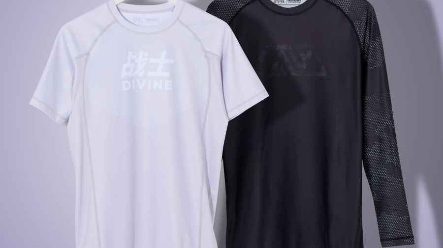 picture showing 2 hanging rashguards. 1 is grey and the other is black.