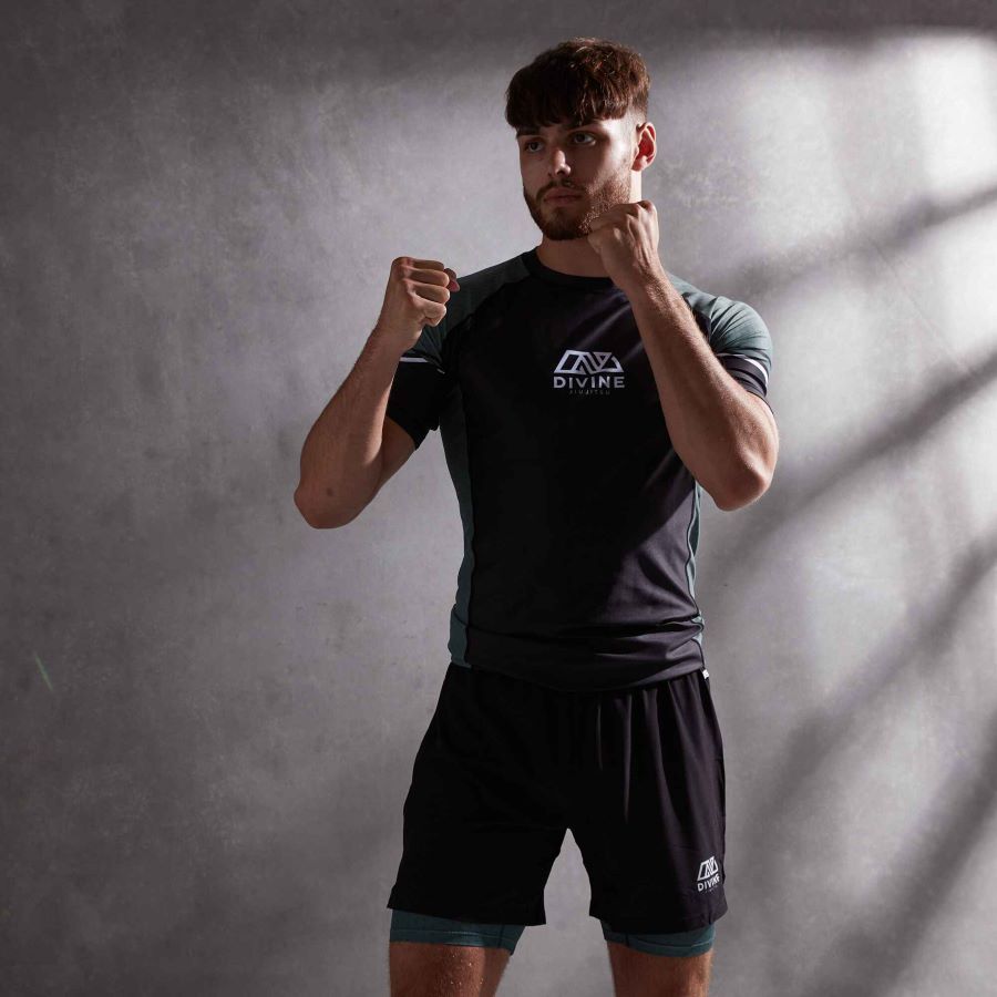 Man in a striking/boxing stance wearing jiu jitsu rashguard and shorts