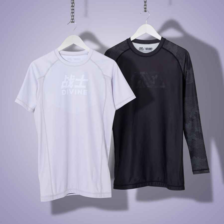 picture showing 2 hanging rashguards. 1 is grey and the other is black.