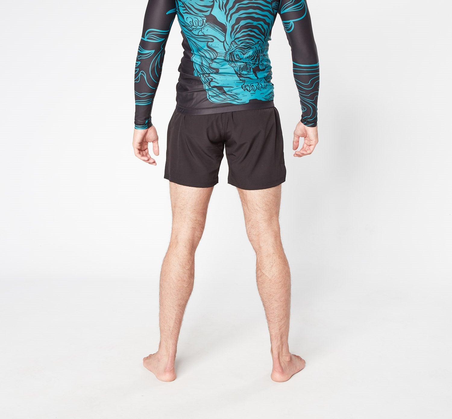 Man in black shorts and blue tiger print rash guard